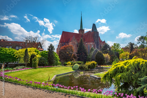 Wroclaw botanical garden with blooming tulips and Church of the Holy Cross and St. Bartholomew. Wroclaw, Poland.