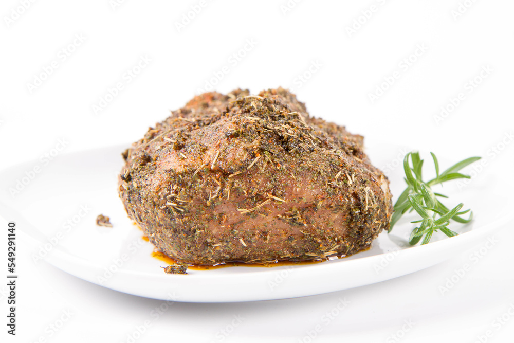 Raw pork loin seasoned - ready to be roasted, on a plate