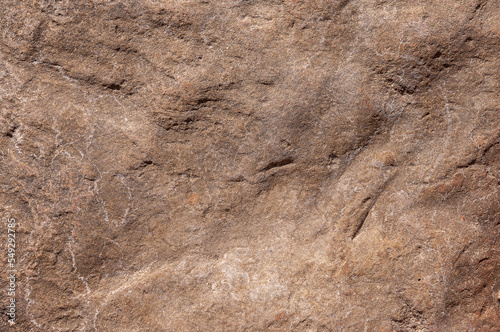 Textured stone background of sand color with different irregularities and patterns. Stone wall is sand-colored.