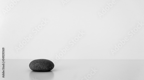 Black oval stone on white table. Concept harmony  balance. Selective focus. Copy space.
