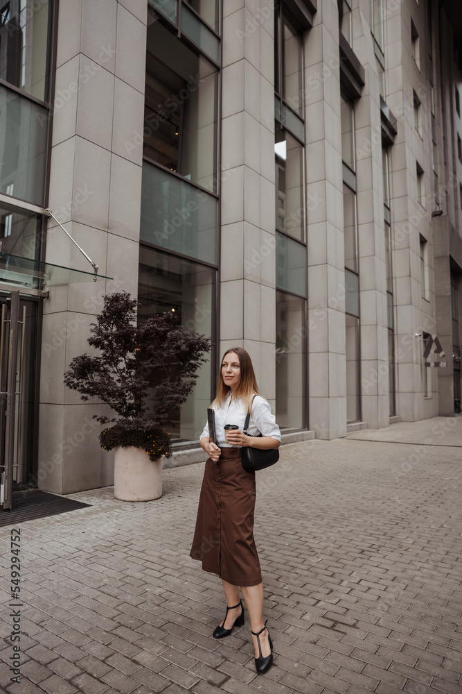 Young business woman holding coffee  of the modern office building background 