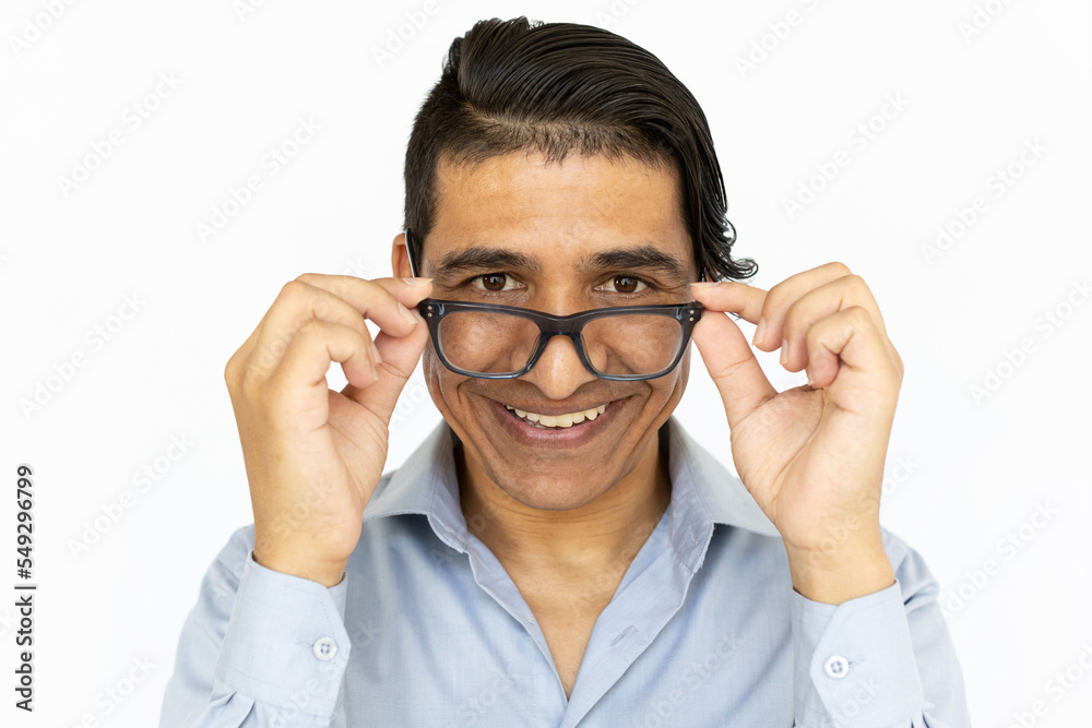 Happy man touching glasses. Indian man in blue shirt with joyful face. Portrait, studio shot, joy concept