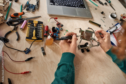 Принти на полотні Partial male engineer soldering microchip at table