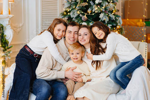Beautiful happy large family on the couch by the Christmas tree. © andrey