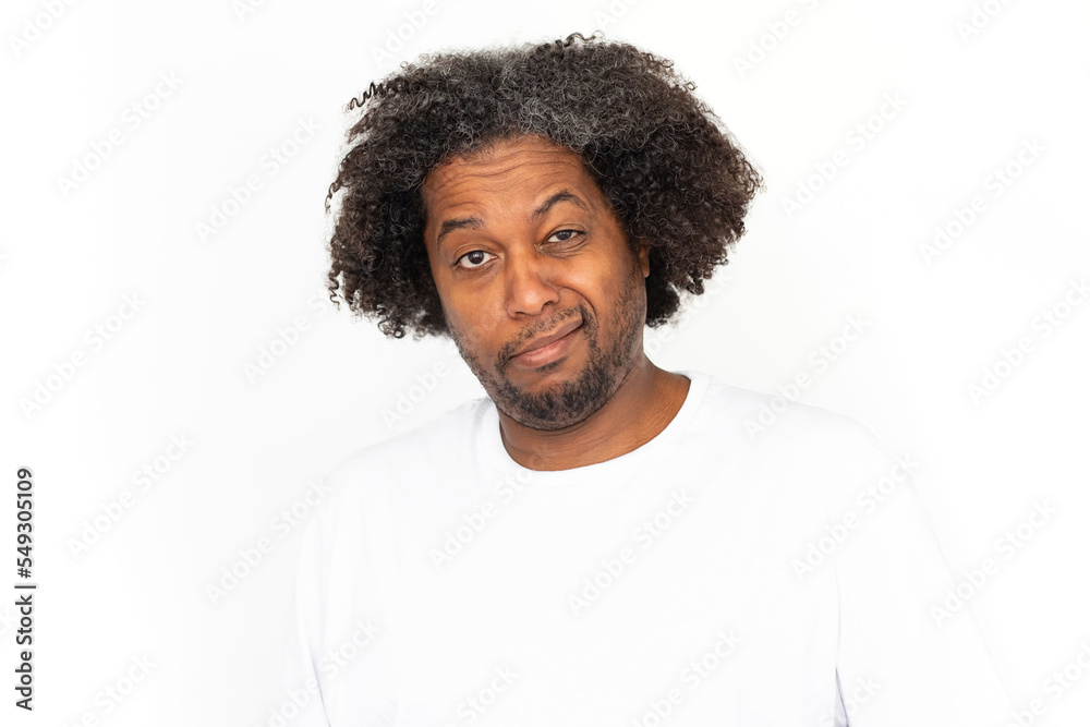 Portrait of disgusted African American man. Unimpressed mature male model with dark curly hair in white T-shirt looking at camera, grimacing or smirking. Dislike, conflict concept Portrait of disgusted African American man. Unimpressed mature male model with dark curly hair in white T-shirt looking at camera, grimacing or smirking. Dislike, conflict concept