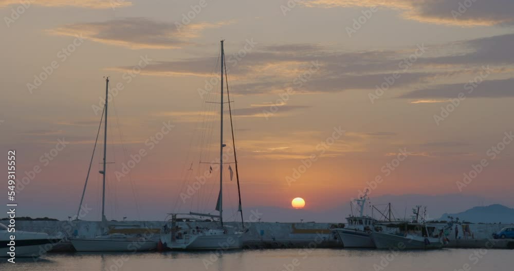 Pleasure and fishing boats stand in the harbour at sunset in the Aegean Sea in Nea Skioni in Greece Pleasure and fishing boats stand in the harbour at sunset in the Aegean Sea in Nea Skioni in Greece