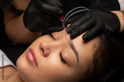 Beauty master doing eyebrow permanent makeup
