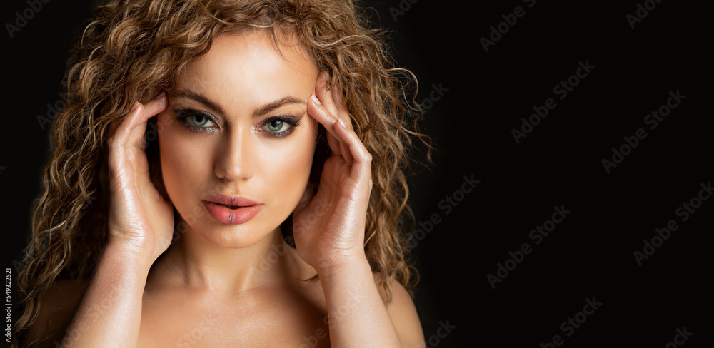 Fototapeta premium Sexy model with wavy hair and glossy skin posing at studio