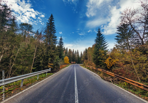 A wonderful autumn landscape of an old asphalt road in the mountains.