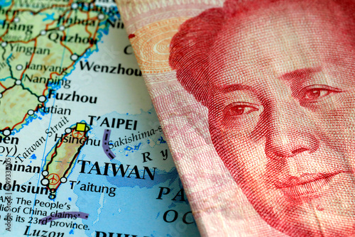 Photography A yuan Chinese banknote on top of a map showing Taiwan