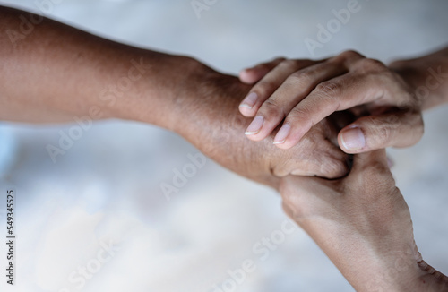 young woman holding hands of elderly woman, caring for the elderly