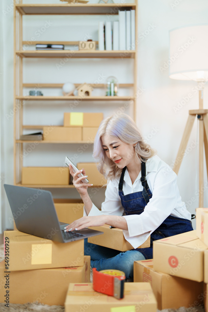 Starting small business entrepreneur of independent Asian woman smiling using computer laptop with cheerful success of online marketing package box items and SME delivery concept Starting small business entrepreneur of independent Asian woman smiling using computer laptop with cheerful success of online marketing package box items and SME delivery concept