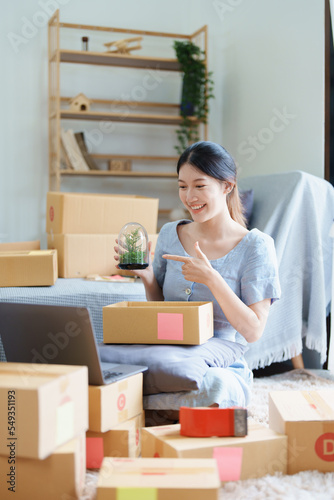 Starting small business entrepreneur of independent young Asian woman online seller using a computer showing products to a customer before making a purchase decision. SME delivery concept