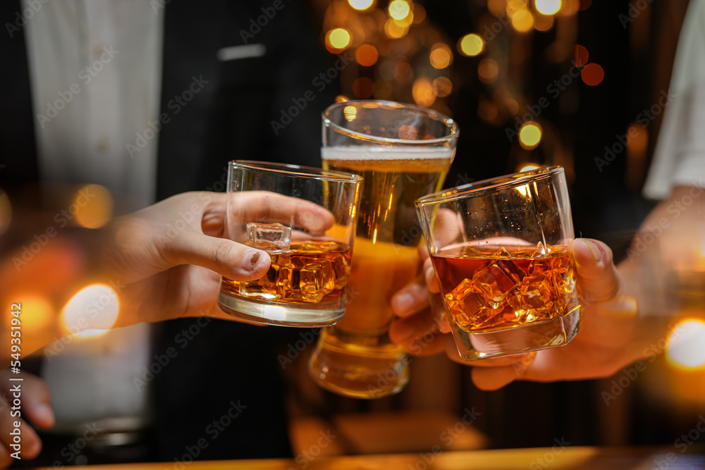 food and drink male friends are happy drinking beer and clinking glasses at a bar or pub. food and drink male friends are happy drinking beer and clinking glasses at a bar or pub.