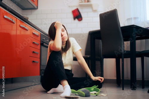 
Unhappy Woman Cleaning up After Broken Plate Incident . Sad girl having an accident in the kitchen 
