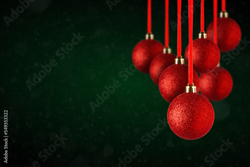 Red Christmas tree ornaments hanging with copy space. Christmas Balls made of glass or plastic hanging over abstract dark green background. photo