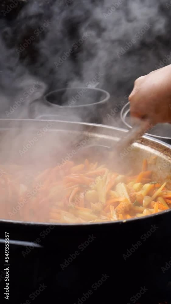 Vertical video, the hand of a person cooking on a wood stove. Vertical video, the hand of a person cooking on a wood stove.