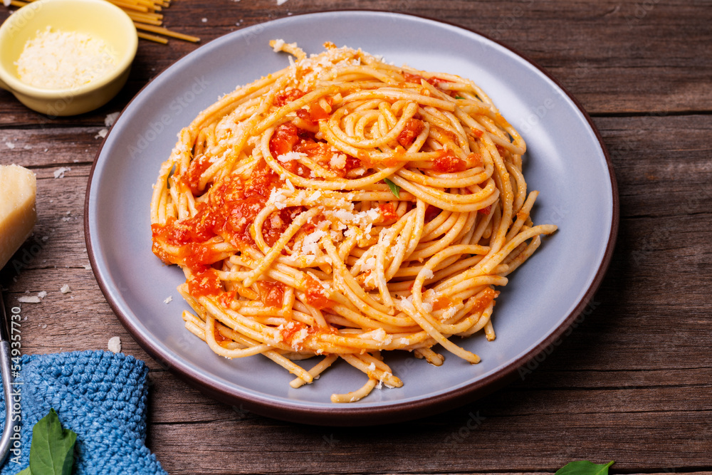 Delicious spaghetti cheese pasta served on a plate Vegetables, Italian tomato sauce and spices arranged on a wooden table, top view Delicious spaghetti cheese pasta served on a plate Vegetables, Italian tomato sauce and spices arranged on a wooden table, top view