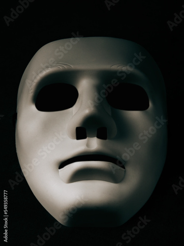 A white mask on a black background is the symbol of the attacking hacker group, this mask is a well-known symbol for anonymous online hacktivist group.copy space.