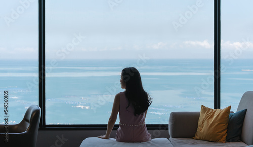 Woman sitting on couch, with ocean view in raining day © SasinParaksa