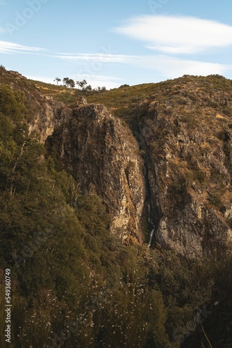 Landscape of high green rocky cliff with plants in Pitoes das Junias Cascata, Portugal photo