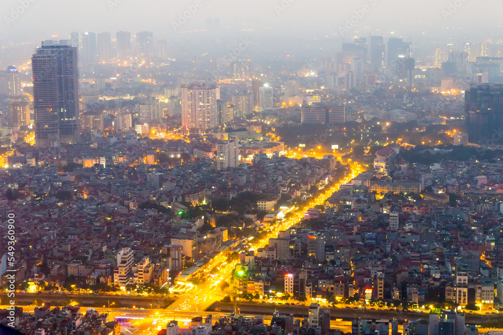 Fototapeta premium Aerial view of car lights on a major arterial road through a large city at Hanoi in Vietnam