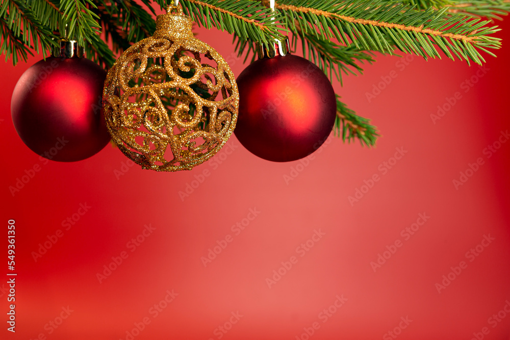 Christmas background with copy space. Festively decorated spruce branches on a red banner. Flat lay style. Christmas background with copy space. Festively decorated spruce branches on a red banner. Flat lay style.