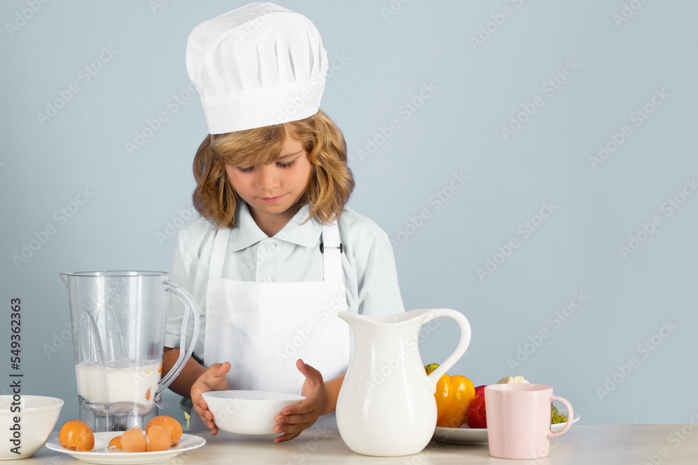 Child chef isolated on blue. Funny little kid chef cook wearing uniform cook cap and apron cooked food in the kitchen. Child chef isolated on blue. Funny little kid chef cook wearing uniform cook cap and apron cooked food in the kitchen.