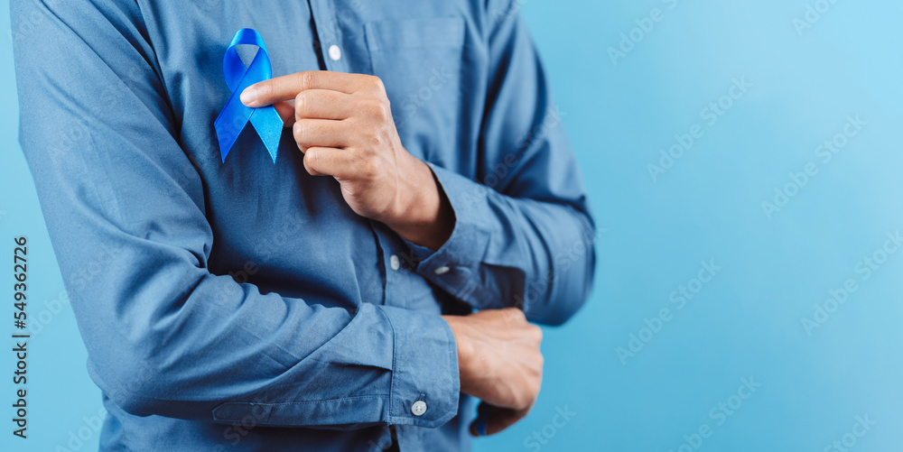 men hands showing Blue ribbon for supporting people living and illness, Colon cancer, Colorectal cancer, Child Abuse awareness, world diabetes day, International Men's Day