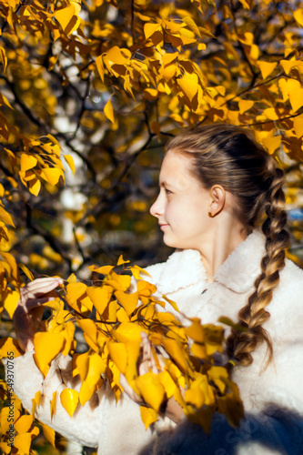 Gold autumn. Portrait of a girl among yellow birch trees.