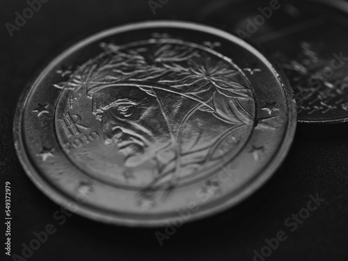 2 two euro coin issued in Italy closeup. Dark black and white money background or backdrop. European Central Bank ECB. Eurozone economy news. Banking and finance. Macro