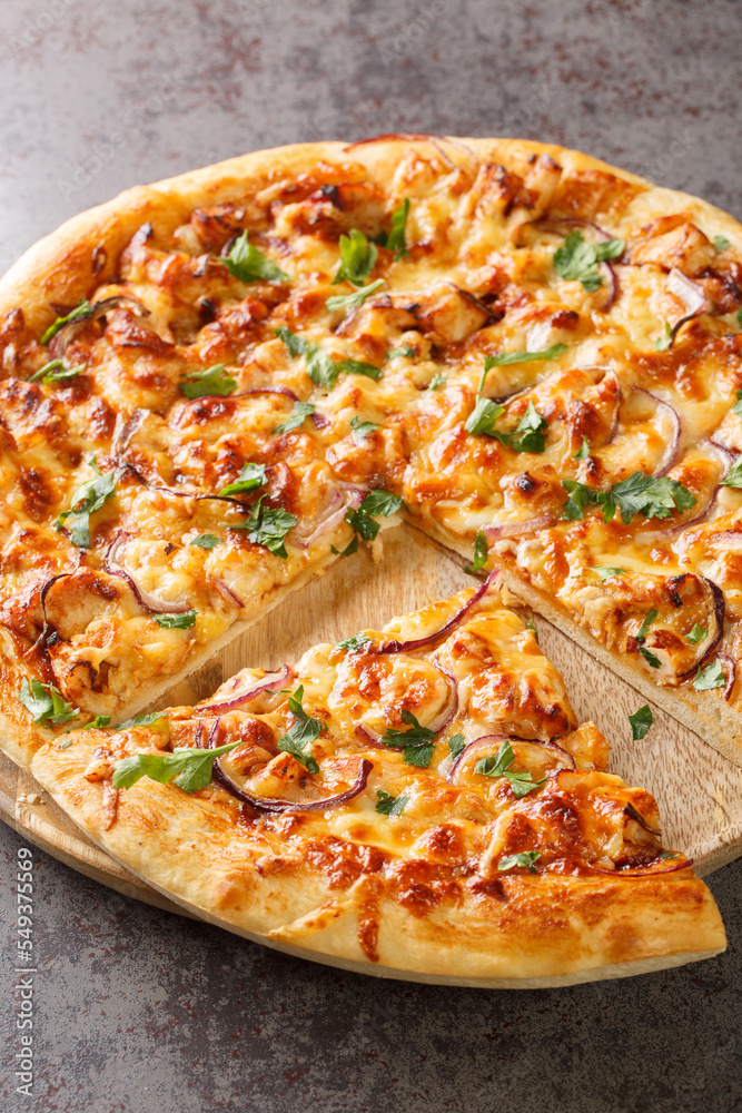 Homemade barbecue chicken pizza with onion and special sauce closeup on the wooden board on the table. Vertical