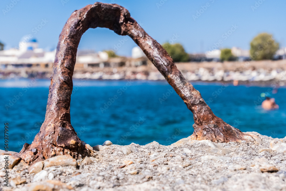 Rusty mooring bollard and Santorini beach on the background Rusty mooring bollard and Santorini beach on the background