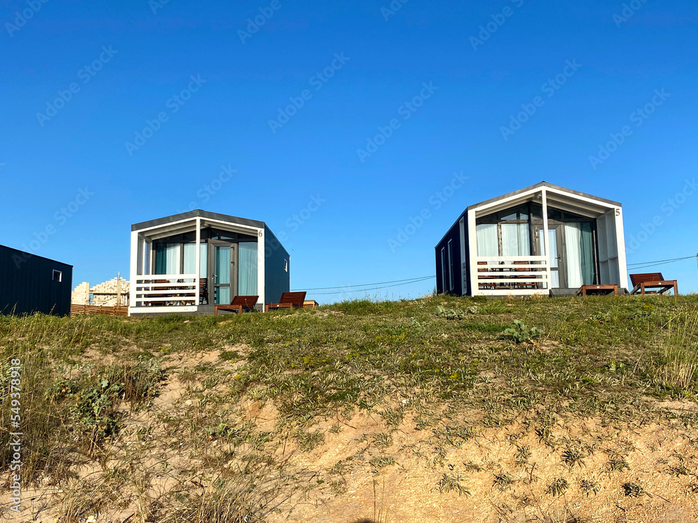 One-story Houses with a porch and a terrace. Panoramic glazing of country Houses. Typical Houses in a cottage village. One-story Houses with a porch and a terrace. Panoramic glazing of country Houses. Typical Houses in a cottage village.