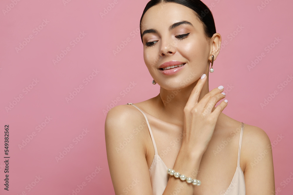 Young woman wearing elegant pearl jewelry on pink background, closeup. Space for text