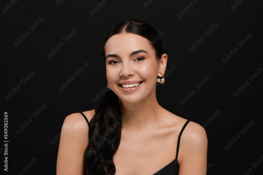 Young woman with elegant pearl earrings on black background Young woman with elegant pearl earrings on black background