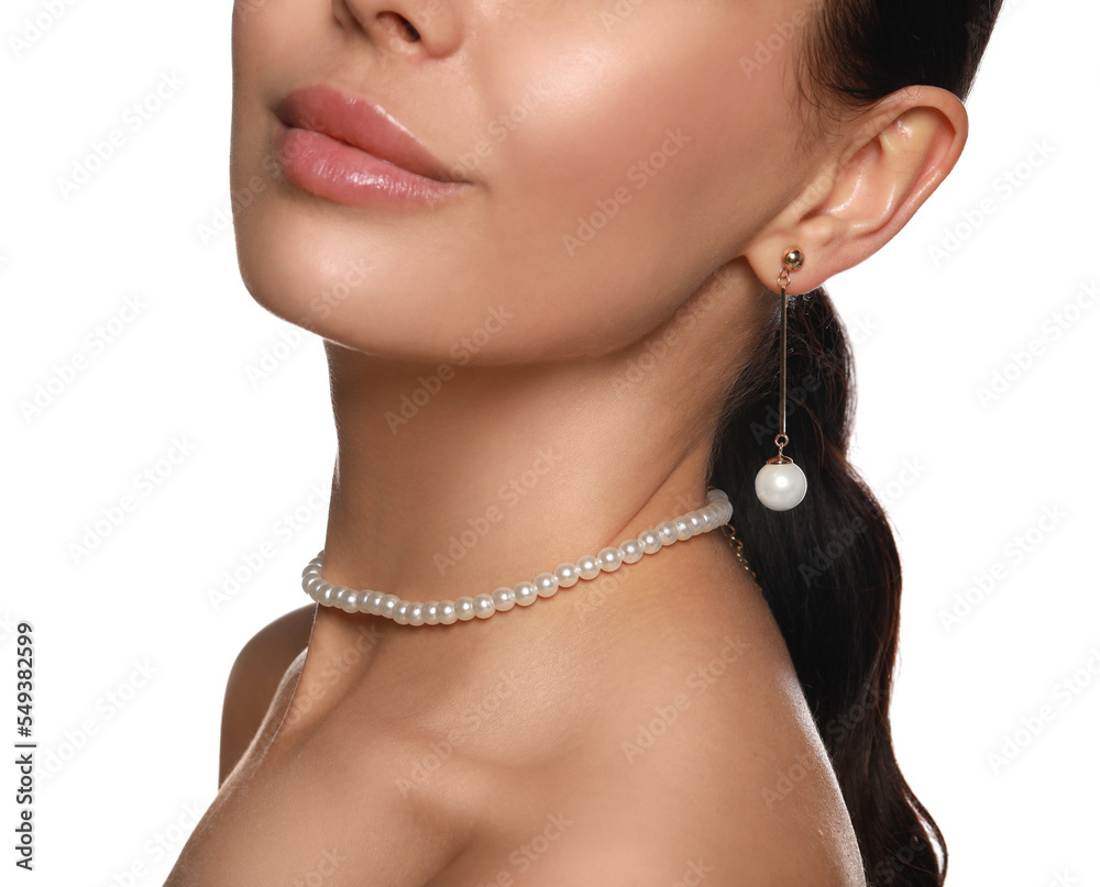 Young woman wearing elegant pearl jewelry on white background, closeup