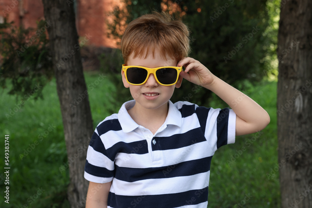 Cute little boy with sunglasses in park Cute little boy with sunglasses in park