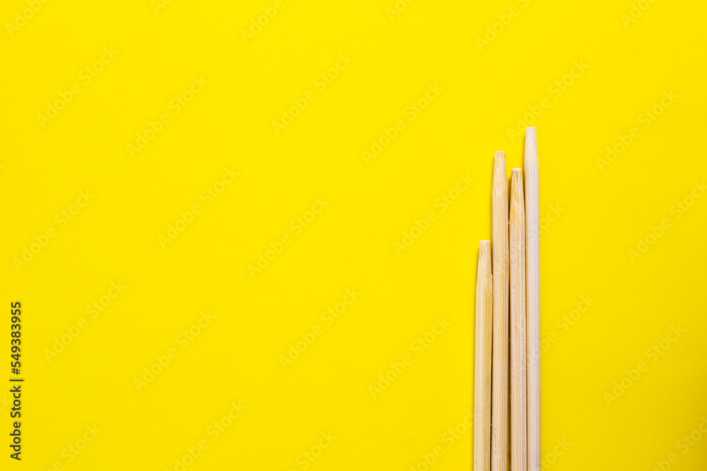 Bamboo chopsticks isolated on yellow background Bamboo chopsticks isolated on yellow background