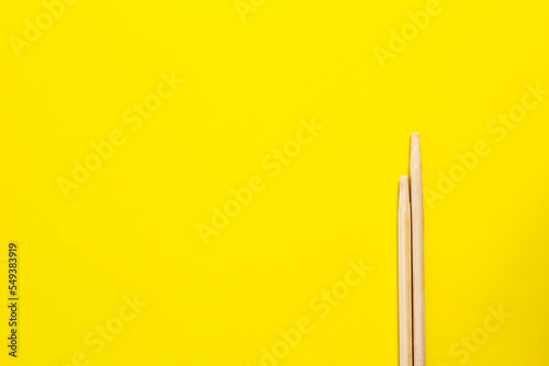 Bamboo chopsticks isolated on yellow background