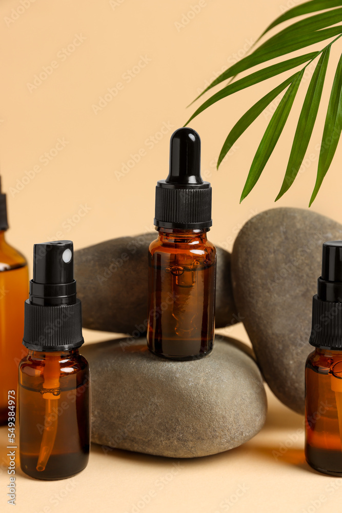 Bottles of organic cosmetic products, green leaf and stones on beige background Bottles of organic cosmetic products, green leaf and stones on beige background