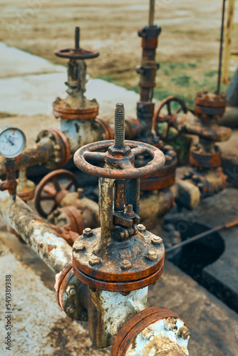 Close-Up Of Valve On Pipeline. Oil Or Gas Transportation With Gas Or Pipe Line Valves On Soil And Sunrise Background. Valve pipes, turn off on gas pump vent.