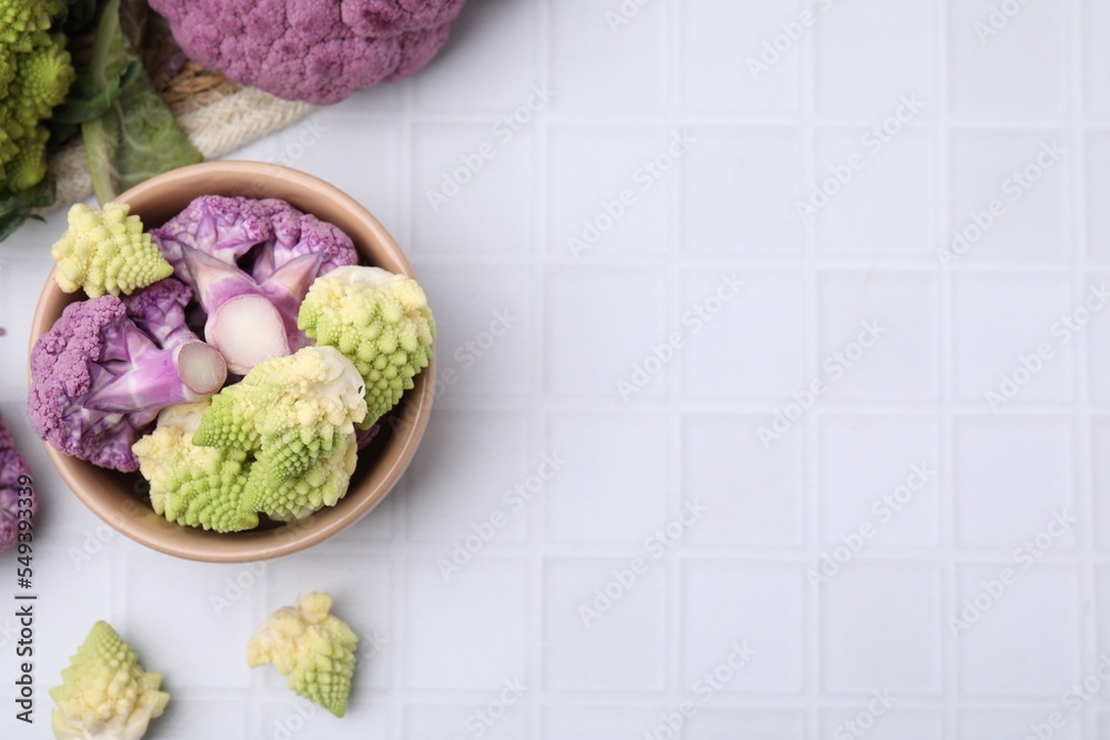 Various cauliflower cabbages on white tiled table, flat lay. Space for text Various cauliflower cabbages on white tiled table, flat lay. Space for text