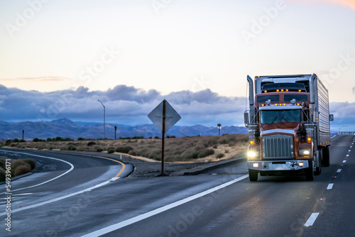 Photography Classic brown big rig semi truck with chrome parts and turned on headlight trans