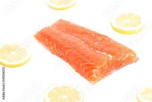 Salmon, fresh raw fish fillet with lemon slices, isolated on white background