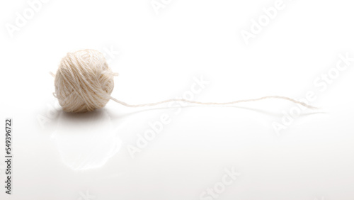 A ball of white woolen threads on a white background with a shadow. Side view. photo