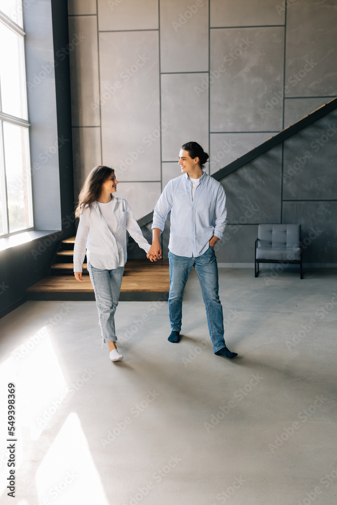 young happy couple man and woman standing in their new cosy appartments after successful real estate deal both smiling wife young happy couple man and woman standing in their new cosy appartments after successful real estate deal both smiling wife