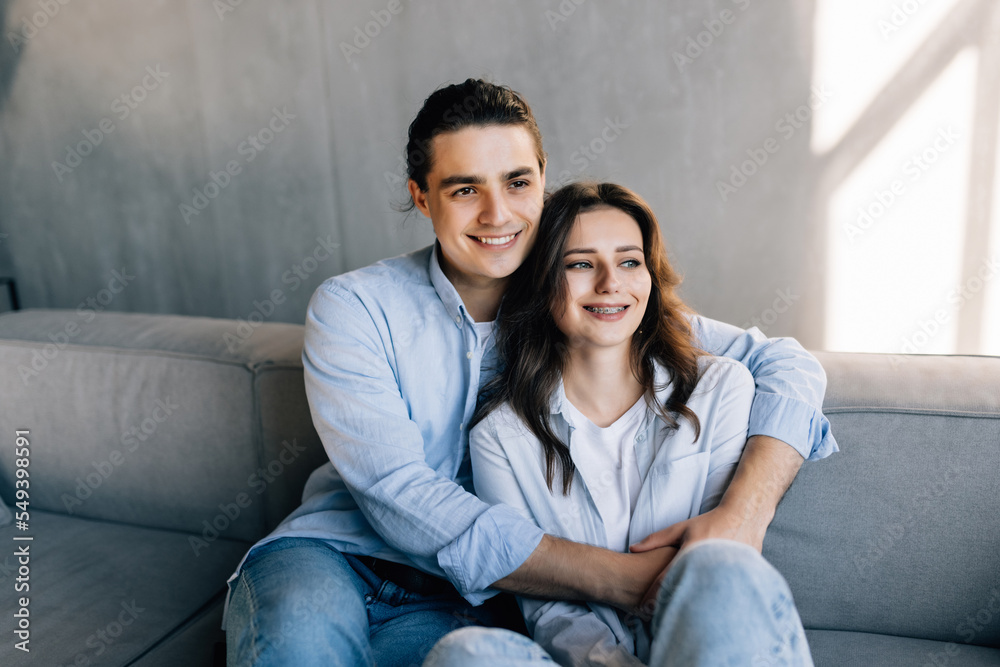 Portrait of young couple in love posing photo shooting seated on couch Portrait of young couple in love posing photo shooting seated on couch