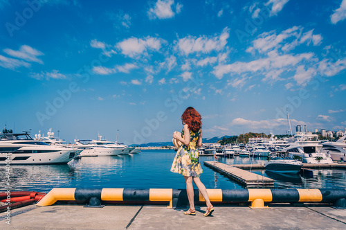 Young girl is looking at the yachts in the Marine Station in Sochi. Summer Vacation. Destination.
