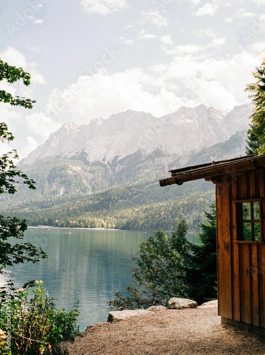 Wooden cabin near the clear lake with a mountain landscape view